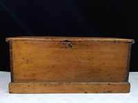 Front view of the antique pine blanket chest showing the flat lid top and dovetail joinery details along the bottom base.