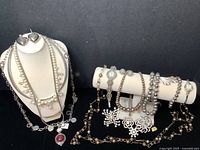 Photo of the entire lot showing necklaces on bust and bracelet bar and scattered jewelry pieces, demonstrating variety and quantity