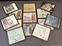 Top-down group view of all 13 Boston sketch prints on board arranged flat showing variety of scenes including street views, architectural details, and abstract elements.