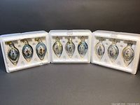 Set of three Bradford Exchange porcelain ornaments in original Styrofoam packaging, blue-tinted with gold accents depicting the Virgin Mary in various scenes.