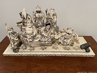 Front view of large vintage Asian sculpture showing seven men in traditional attire with turtles on base