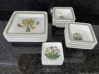 View of all plates, mini bowls, and dipping dishes grouped and stacked on counter showing variety and size differences