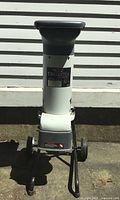 Full view of the white and grey electric garden shredder with wheels and feed chute, showing its overall shape and condition.