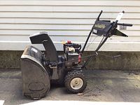 Side view of black Yard Machine MTD snowblower showing chute, tires, and handle.