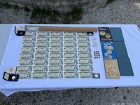 Full lot overview showing uncut banknote sheet, tokens, coins, books and albums