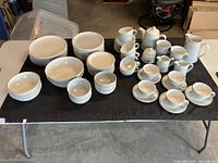 Overview of entire Denby Spirit dinnerware assortment displayed on black table.