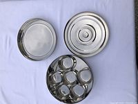 Top-down view of the spice container, showing multiple round bowls arranged in a circular tray with matching lids