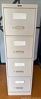 Front view of beige Pro Source 4-drawer filing cabinet showing drawer handles and label holders