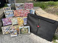 Overview of all puzzle boxes arranged outdoors with puzzle mat beside them.