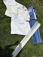 White King Canopy shade fabric, sidewalls, white metal poles, and blue carrying bag laid on grass.