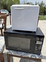 Side view of Toastmaster Breadmaker on top of Panasonic microwave oven, showing overall lot setup.
