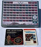 Top-down photo showing the full puzzle box with tartan patterns and two tartan-themed books placed in front.