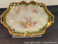 Full view of the antique oval serving bowl showing floral design, perforated gold rim, and handles.