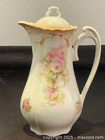 Front view of the antique German porcelain chocolate pot featuring hand painted floral decoration with pink roses and gold trim details.