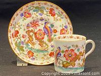 Close up showing detailed floral and bird pattern on espresso cup and saucer set