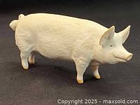 Side view of white Beswick porcelain pig figurine showing textured details and curled tail.