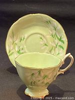 Tea cup placed inside matching saucer showing floral design and gold trim.