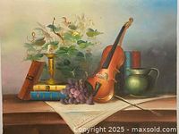 Front view of the still life oil painting showing detailed composition with violin, grapes, books, candle holder, pitcher, and plant.