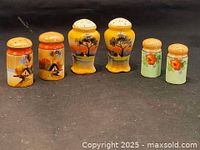 Full view of three pairs of vintage porcelain salt and pepper shakers arranged in a row showing all sets