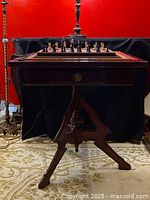 Front view of Victorian mahogany chess table with chessboard and pieces set up, showing tripod leg design and drawer