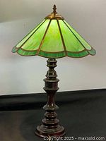 Full view of the table lamp showing the green slag glass shade and brass base