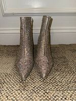 Front view of silver rhinestone ankle boots, pointed toe visible, and boots standing upright.