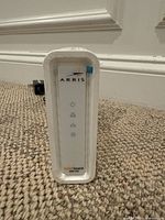 Front view of Arris Surfboard SB6190 cable modem with logos and indicator lights visible.
