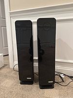 Front view of two GermGuardian black electric air purifiers standing side by side on a carpeted floor.