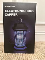 Box front showing HEMIUA Electronic Bug Zapper branding and image of bug zapper device.
