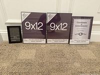 Four black Studio Decor picture frames arranged on carpet: two 9x12 inch, one 8.5x11 inch and one 4x6 inch displaying certificate