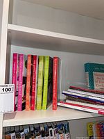 Cookbooks on a shelf, including six titles from the Barefoot Contessa series along with other assorted cookbooks stacked on right side.