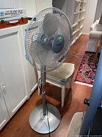 Full view of silver floor fan showing height and blade guard with Sylvania branding.