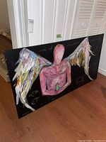 Full view showing the colorful winged humanoid figure with faceless head, textured brushstrokes, and black background.