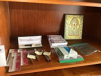 Shelf with pens, refills, staples boxes, index cards, and a small decorative book