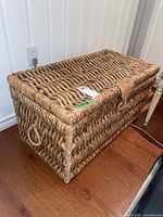 View of the front of woven chest showing thick rope weave and lid with toggle closure.