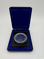 Front view of 1976 Canadian silver dollar coin showing the reverse side with building design and centennial years