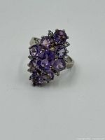 Front view close-up of the ring showing cluster of amethyst stones in silver setting.