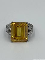 Front view showing square-cut citrine center with clear accent stones