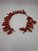 Full view of the coral branch necklace laid out with visible hook-style closure at the end.