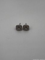 Front view showing square shape with central diamond and pavé stones around.