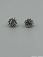 Front view of the pair of diamond cluster stud earrings, showing the detailed floral/starburst pattern of the diamonds