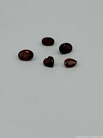 Five garnet gemstones on a white background showing their shape and size