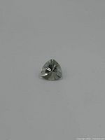 Front view of the trilliant cut iolite gemstone showing its triangular shape and faceting pattern.