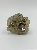 Front angle of the jade dragon carving showcasing detailed facial features and coiled shape.