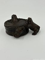 Side view showing one frog inside and one climbing the tub, details of texture and tub panels visible