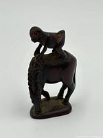 Front angle showing carved monkey on horse with detailed mane and body posture.