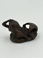 Side view of the carved netsuke mermaid showing the detailed tail and hair.