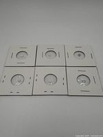 Six individual 3mm opal stones mounted in white cardboard holders with transparent plastic window, arranged in two rows of three.