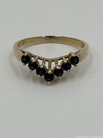 Front view of gold vermeil ring with seven small round blue sapphires set in a row.