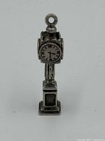 Front view of the sterling silver Birks pendant charm shaped as a street clock on a pedestal base